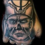 Demonic face hand tattoo